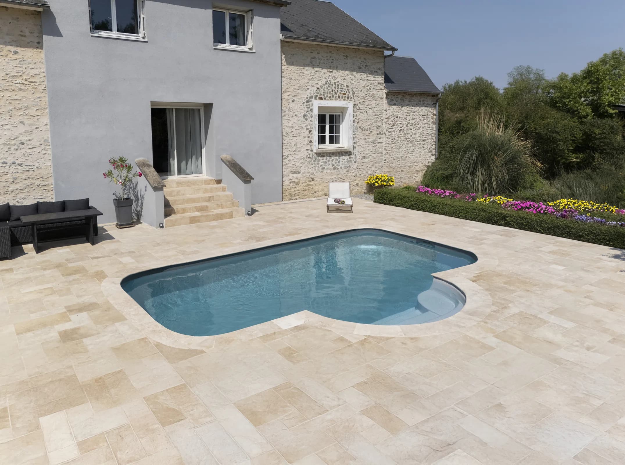 Pool mit gerundeter Treppe in einem weitläufigen Gartenhof