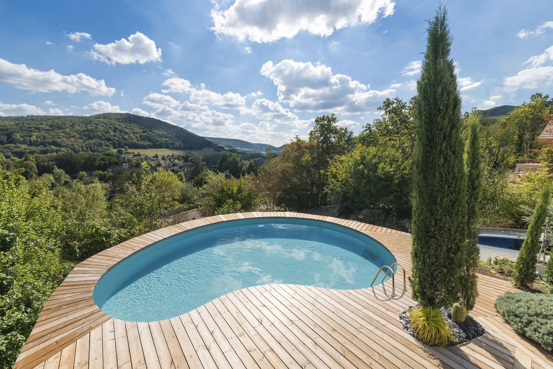 Pool in einem sonnigen Garten mit freiem Blick in die Landschaft
