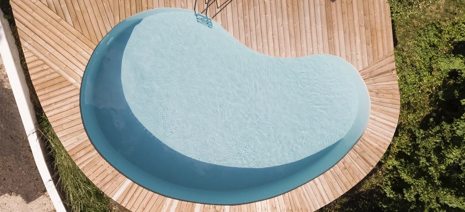 Adele-Pool aus der Vogelperspektive mit geschwungener Holzterrasse