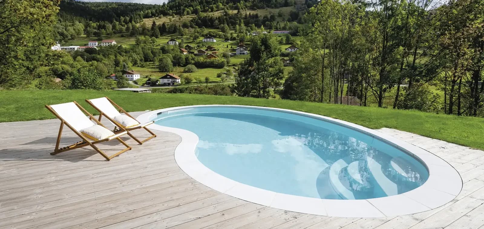 Heller Adele-Pool mit Liegestühlen und Blick in eine grüne Landschaft