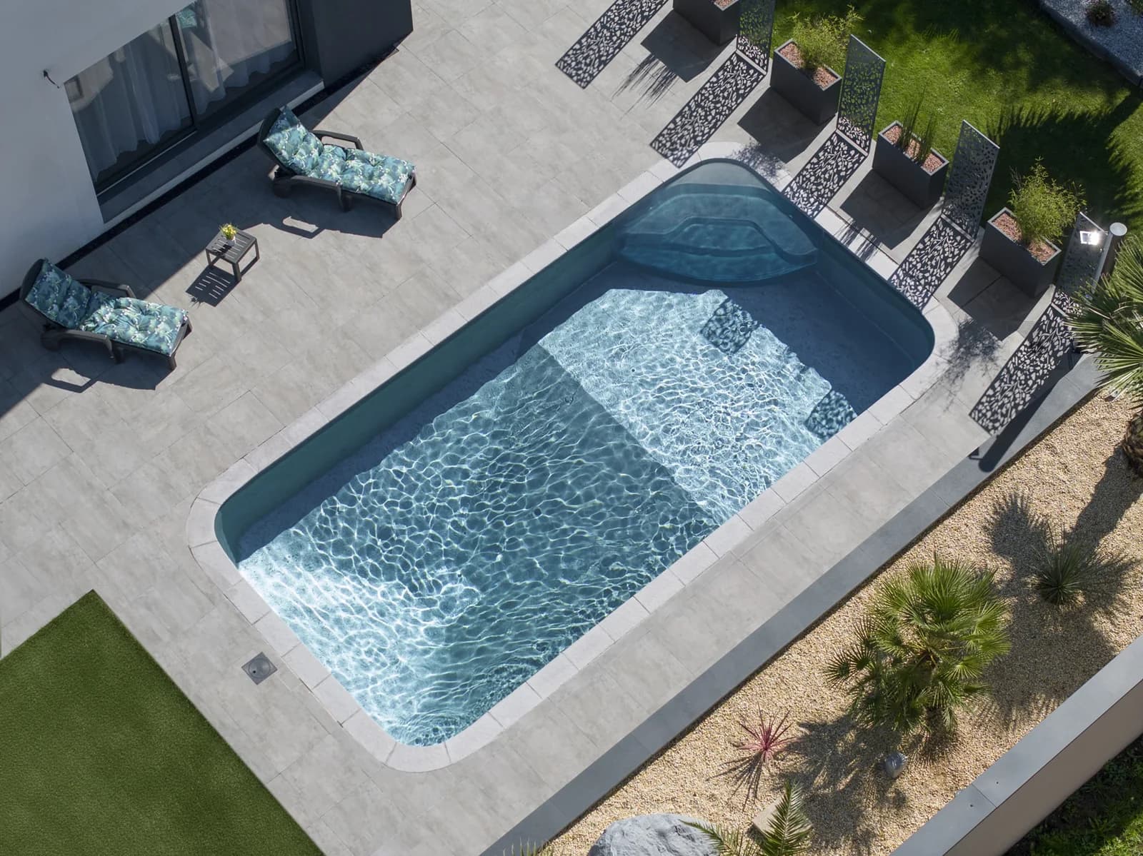 Romy-Pool aus der Luft mit dunkler Wasserfläche und moderner Terrasse