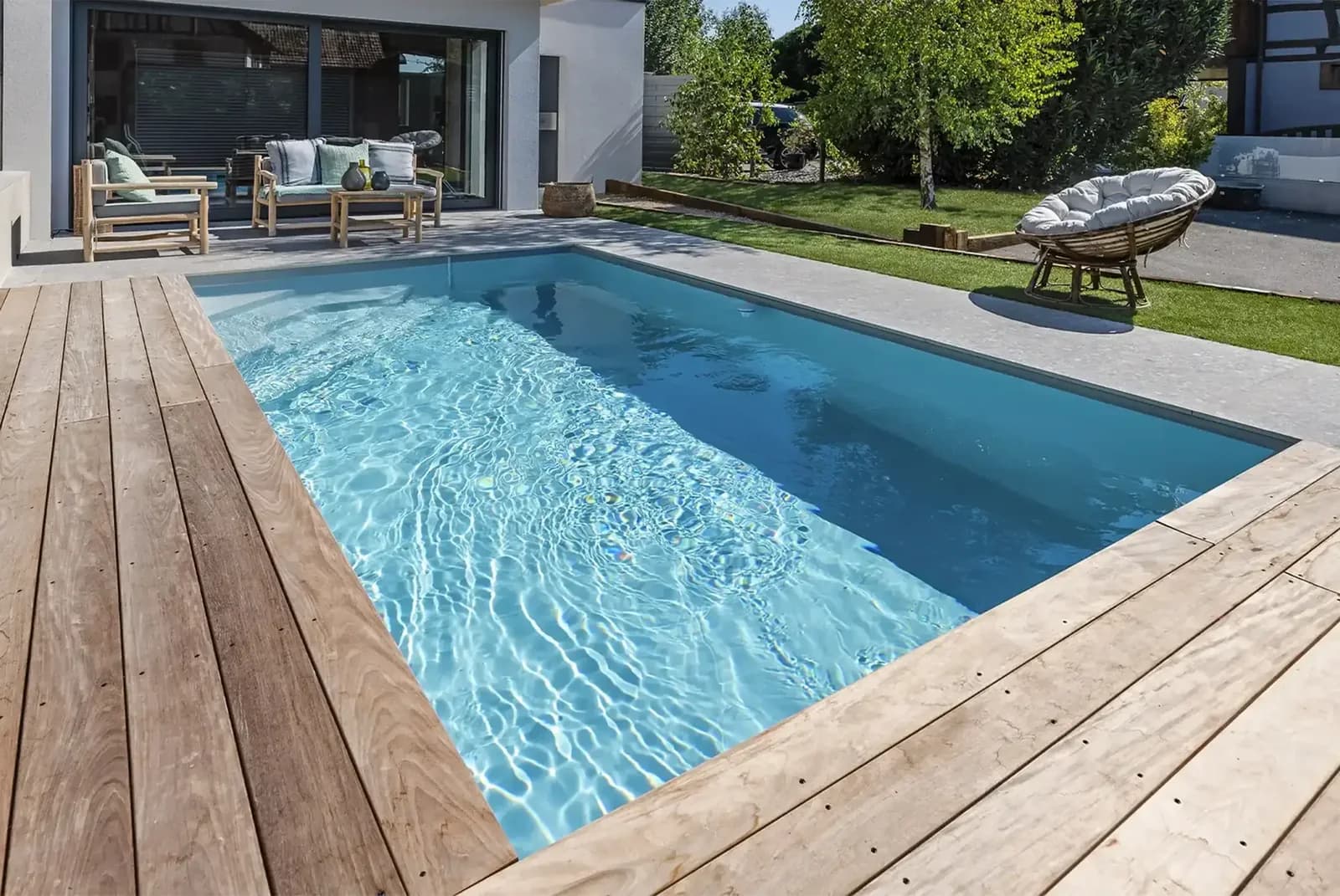 Tina-Pool mit Holzterrasse vor einem modernen Wohnhaus